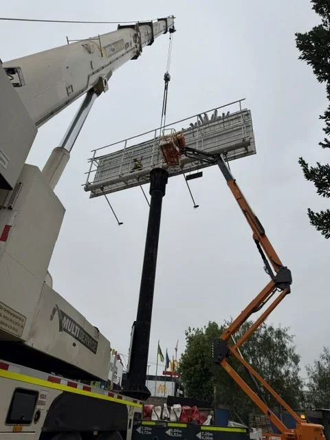 Grúa retirando la estructura de un letrero