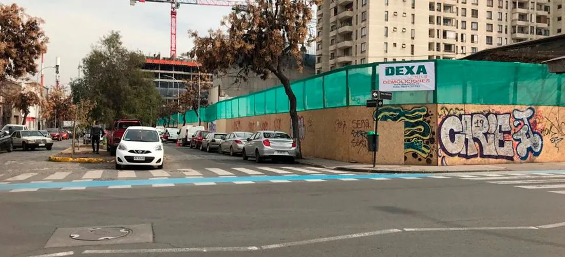 Cierre de obra de DEXA Chile en una esquina de Santiago, con la torre grúa al fondo