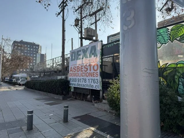 Letrero de DEXA Chile en el cierre de una obra en Vitacura